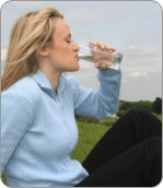 Femme buvant une bouteille d'eau minérale