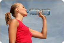 Une femme d'allure sportive en train de boire une bouteille d'eau