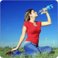 Jeune femme pleine de vitalité buvant une bouteille d'eau minérale