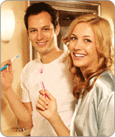 Jeune couple souriant tenant un stylo chacun
