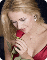 Femme se concentrant en regardant une rose tenue dans sa main