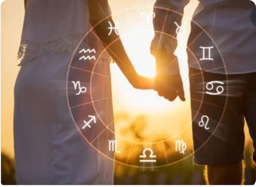 Couple se tenant par la main à contre-jour avec le zodiaque en superposition