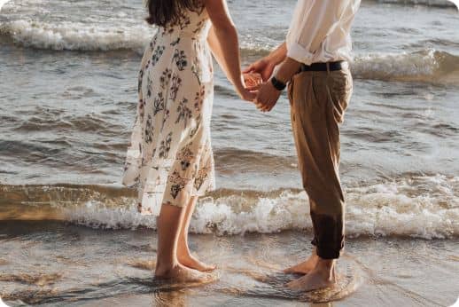 Couple se tenant les mains sur la plage au bord de mer