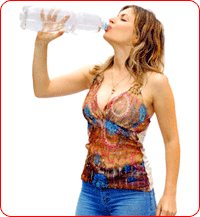 Jeune femme sportive en train de boire une bouteille d'eau minérale