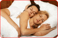 Un couple enlacé en plein sommeil dans leur lit
