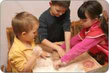 Image de trois jeunes enfants participant ensemble à une activité autour d'une table