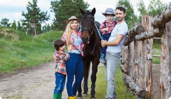 Famille (père, mère, garçon, fille) à la campagne, en compagnie d'un cheval
