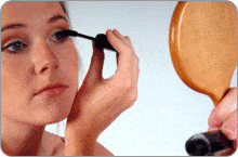 Femme se maquillant devant un miroir