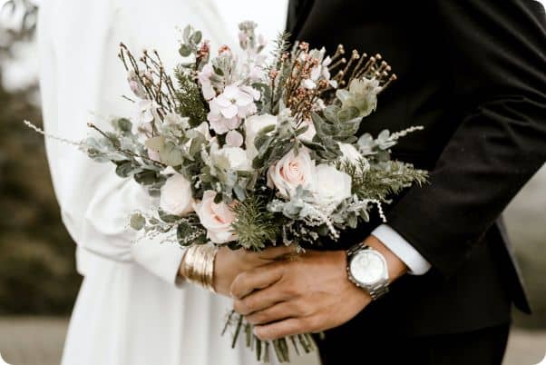 Couple de mariés avec le bouquet de fleurs