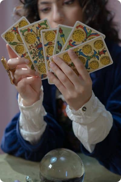 Sept cartes de tarot dans la main d'une tarologue